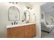 Bright bathroom features a double sink vanity with light wood cabinets, black hardware, and modern arched mirrors at 2525 Ashton Dr, Roswell, GA 30076