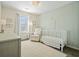 Charming Bedroom with a white crib, soft rug, patterned wallpaper and a comfortable chair at 2525 Ashton Dr, Roswell, GA 30076