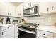 Updated kitchen features stainless steel appliances, white cabinets, and solid surface countertops at 2525 Ashton Dr, Roswell, GA 30076