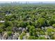 An aerial view of the home nestled among lush trees with the Atlanta skyline in the distance at 446 Harold Ne Ave, Atlanta, GA 30307