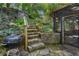 Stone steps lead to a screened porch in a lush backyard with a barbecue grill at 446 Harold Ne Ave, Atlanta, GA 30307