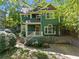 Inviting green home with well-maintained landscaping and a charming front porch entry at 446 Harold Ne Ave, Atlanta, GA 30307