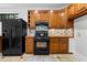 Traditional kitchen features wooden cabinets, black appliances, tile backsplash, and brick colored countertops at 446 Harold Ne Ave, Atlanta, GA 30307