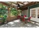 Outdoor view from covered sunroom, including ceiling fan, stone wall, and an arrangement of outdoor furniture and decor at 446 Harold Ne Ave, Atlanta, GA 30307