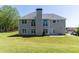 Back exterior of a two-story home featuring a large backyard with plenty of green space at 100 Wyngate Chase, Stockbridge, GA 30281