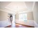 Bright and airy living room with a tray ceiling, chair railing, and large window at 100 Wyngate Chase, Stockbridge, GA 30281