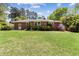 Charming brick home with a large, well-manicured lawn and mature landscaping in the backyard at 1301 Amanda Cir, Decatur, GA 30033
