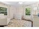 Cozy Bedroom with a white crib, plush armchair, and soft patterned rug beneath a ceiling fan at 1301 Amanda Cir, Decatur, GA 30033