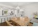 Bright dining room with hardwood floors, a beaded chandelier, and an adjacent modern kitchen at 1301 Amanda Cir, Decatur, GA 30033