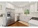 White cabinets, quartz counters, stainless steel appliances and hardwood flooring in this bright kitchen at 1301 Amanda Cir, Decatur, GA 30033