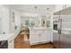 Stylish kitchen island with white cabinets, quartz countertops, and stainless steel appliances nearby at 1301 Amanda Cir, Decatur, GA 30033