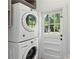 Efficient laundry room with stacked washer and dryer and a view of the backyard through a windowed door at 1301 Amanda Cir, Decatur, GA 30033