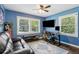 Blue office featuring a large window, ceiling fan, dark-stained wood floors, and comfortable furniture at 1301 Amanda Cir, Decatur, GA 30033