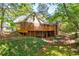 Charming home showcasing a large deck, brick exterior and lush landscaping in the backyard at 1851 Mount Vernon Rd, Dunwoody, GA 30338