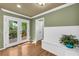Bright entryway featuring hardwood floors, white wainscoting, and French doors leading to the outdoor deck at 1851 Mount Vernon Rd, Dunwoody, GA 30338