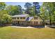 Inviting two-story home with brick and siding, surrounded by mature trees and a green lawn at 1851 Mount Vernon Rd, Dunwoody, GA 30338