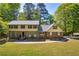 Charming two-story home with lush green lawn, brick accents, and mature trees at 1851 Mount Vernon Rd, Dunwoody, GA 30338