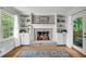 Cozy brick fireplace with built-in bookshelves, cabinets, and a view to the backyard at 1851 Mount Vernon Rd, Dunwoody, GA 30338