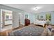 Sunlit main bedroom with an ensuite bathroom, blue walls, a white bed, and a stylish area rug at 1851 Mount Vernon Rd, Dunwoody, GA 30338