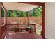A charming back porch with a wooden bench and planters, perfect for enjoying the serene, wooded backyard at 5011 Weathervane Dr, Alpharetta, GA 30022