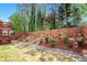 Fenced backyard featuring tiered landscaping, lush greenery, and a multi-level deck, perfect for outdoor enjoyment at 5011 Weathervane Dr, Alpharetta, GA 30022