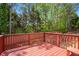 Spacious wood deck overlooking a beautifully landscaped backyard with lush greenery and tall trees at 5011 Weathervane Dr, Alpharetta, GA 30022