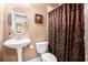 Bathroom featuring a pedestal sink, neutral walls, and a decorative shower curtain at 5011 Weathervane Dr, Alpharetta, GA 30022