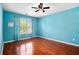 Comfortable bedroom featuring beautiful natural light, hardwood floors, and a ceiling fan at 5011 Weathervane Dr, Alpharetta, GA 30022