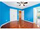 Bright bedroom featuring hardwood floors, ceiling fan, and access to other rooms at 5011 Weathervane Dr, Alpharetta, GA 30022