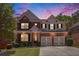 Beautiful two-story brick home featuring a two-car garage, manicured lawn, and lovely landscaping at 5011 Weathervane Dr, Alpharetta, GA 30022
