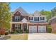 Charming two-story home with brick and siding, a two-car garage, and well-maintained front yard at 5011 Weathervane Dr, Alpharetta, GA 30022