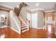 Bright foyer with hardwood floors, a staircase with white railings, and access to a powder room at 5011 Weathervane Dr, Alpharetta, GA 30022