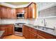 Close-up of a kitchen featuring wood cabinets, granite counters, and stainless steel appliances at 5011 Weathervane Dr, Alpharetta, GA 30022