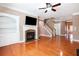Inviting living room features a fireplace, built-in shelving, hardwood floors, and a ceiling fan at 5011 Weathervane Dr, Alpharetta, GA 30022