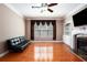 Cozy living room with hardwood floors, a fireplace with built-ins, and a large window with stylish drapes at 5011 Weathervane Dr, Alpharetta, GA 30022
