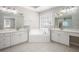 Bright bathroom with white tile, double sinks, large mirrors, and natural light at 4609 Mctyre Way, Marietta, GA 30064