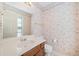 Bathroom featuring a single sink vanity, toilet and floral wallpaper at 595 Saint James Se Walk, Marietta, GA 30067