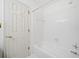 Bright bathroom with white tiled walls and floors, featuring a tub/shower combo at 595 Saint James Se Walk, Marietta, GA 30067