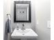 Well-lit bathroom features a pedestal sink, mirror, and modern fixtures at 900 Hillary Ln, Lawrenceville, GA 30043