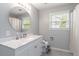 Bright bathroom features a marble vanity, oval mirror, and tile flooring at 900 Hillary Ln, Lawrenceville, GA 30043