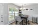 Cozy dining area features a modern chandelier, large window, and wood-look flooring at 900 Hillary Ln, Lawrenceville, GA 30043