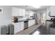 Bright kitchen features white cabinets, stainless steel appliances, granite countertops and wood-look floors at 900 Hillary Ln, Lawrenceville, GA 30043
