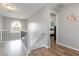 Upstairs landing with hardwood floors, elegant lighting, and view of the primary bedroom at 900 Hillary Ln, Lawrenceville, GA 30043