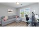 Cozy, light-filled room features a gray sofa, window, and desk setup at 900 Hillary Ln, Lawrenceville, GA 30043