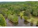 Aerial view of lush, green community featuring a pond, walking trails, and mature trees at 9295 Martin Rd, Roswell, GA 30076