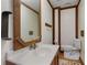 Rustic bathroom features a wood framed mirror and vanity with white countertops at 9295 Martin Rd, Roswell, GA 30076