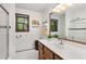 Bright bathroom with a large mirror, a wooden vanity, and a tiled walk-in shower at 9295 Martin Rd, Roswell, GA 30076