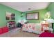 Cozy bedroom featuring bright green walls, a floral comforter, and a dedicated study area at 9295 Martin Rd, Roswell, GA 30076