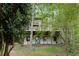 Rear exterior view of the home featuring multiple levels, decks, and a wooded backdrop at 9295 Martin Rd, Roswell, GA 30076