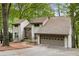 Charming two-story home with a stone facade accent and an attached two-car garage nestled among mature trees at 9295 Martin Rd, Roswell, GA 30076